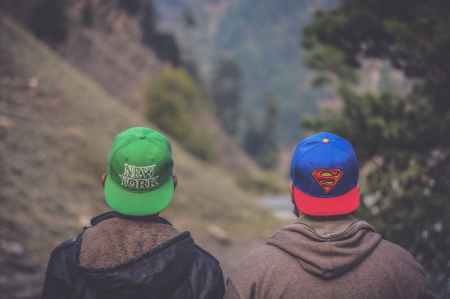 shallow focus photography of two men wearing caps